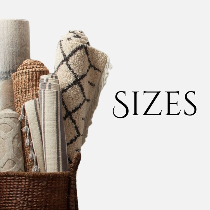  A collection of rolled rugs and textiles in a woven basket, showing a variety of patterns and textures, including a geometric black-and-white rug and beige woven designs. The word "SIZES" is displayed in bold black text on the right side of the image.